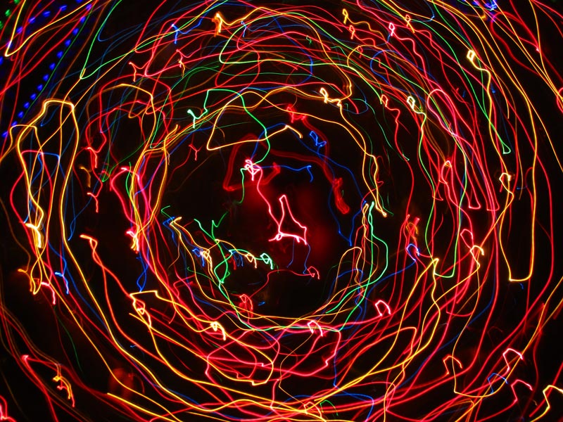 Colourful circular light trails from christmas lights on a black background